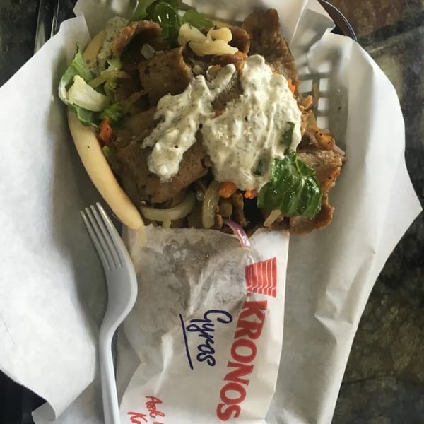 King Of Gyros' Greek gyros with meat, lettuce, onions, and tzatziki sauce in a basket.